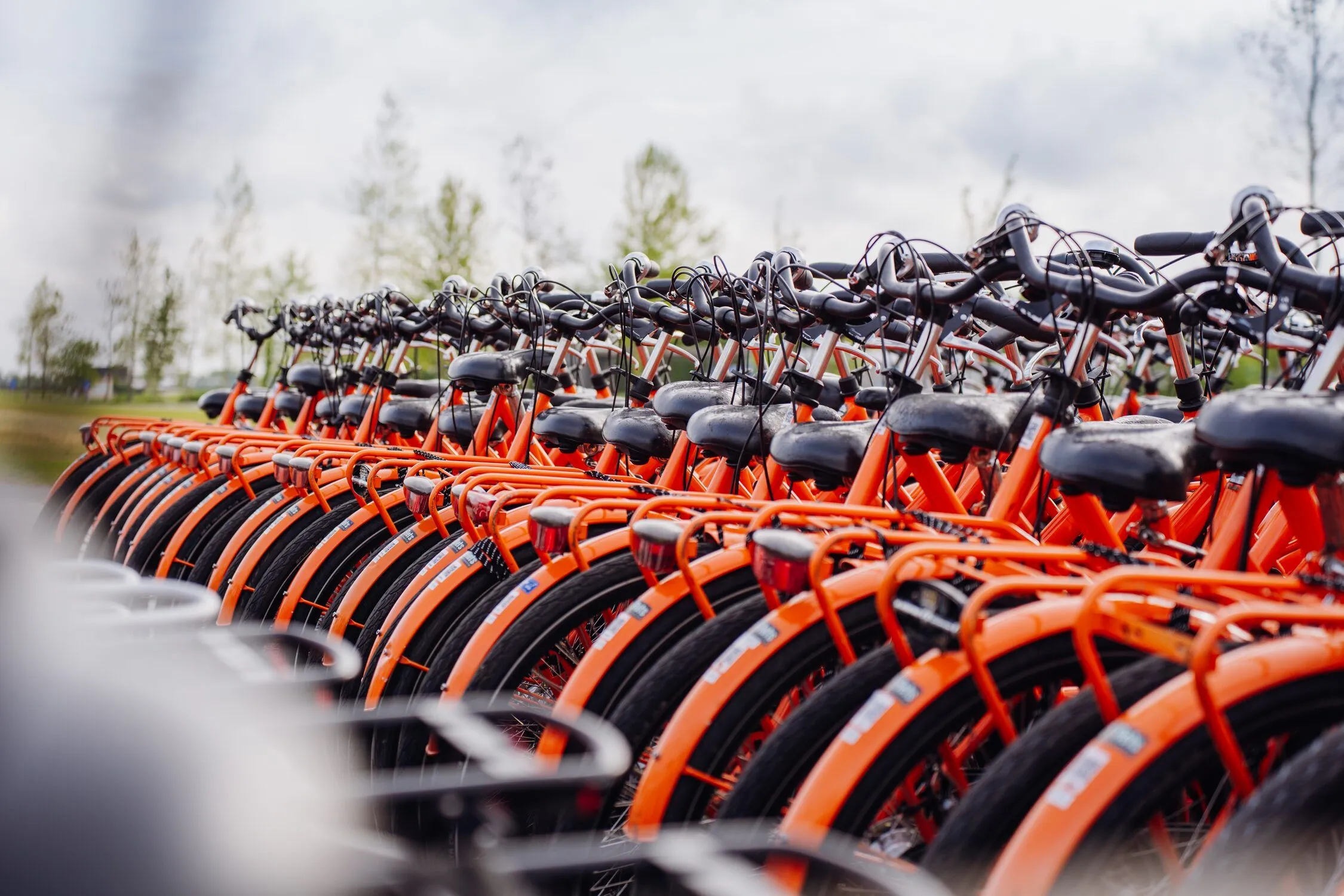 Een rij oranje deelfietsen klaar voor gebruik 
